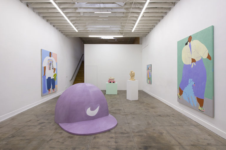 Installation image for Lilian Martinez's Bart Beethoven Wifi show, of about three paintings hanging on the wall of the gallery and 3 sculptures placed on a floor and high platforms
