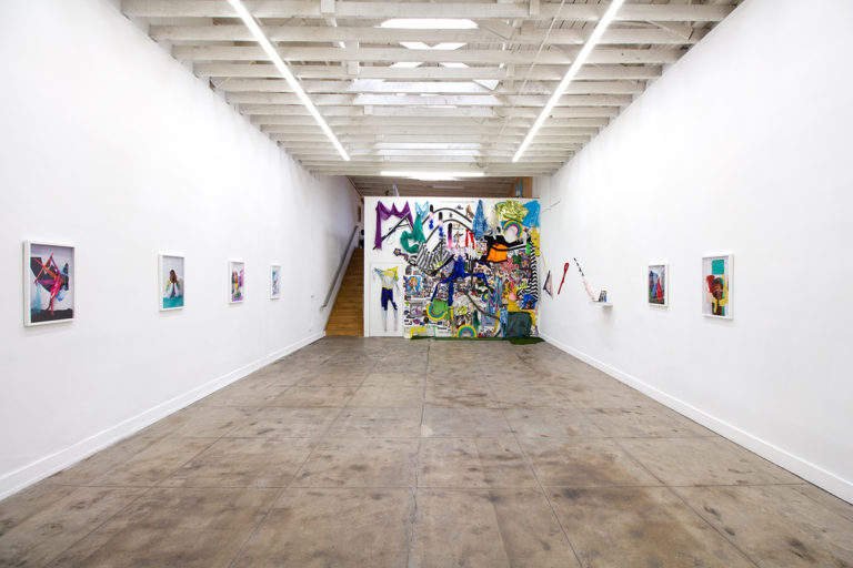 Installation image for Rakeem Cunningham's Hero show, of all the items he used and six portraits hanging on the wall
