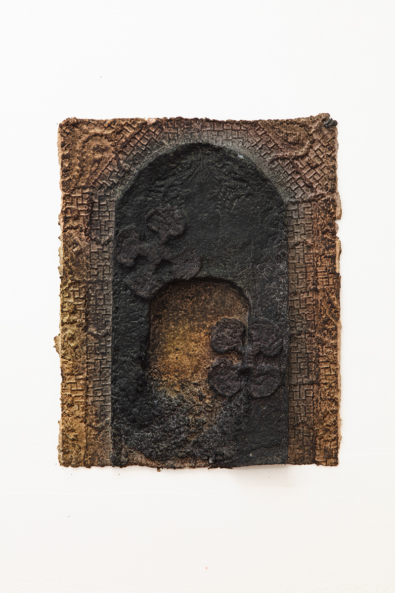 Brown handmade dyed paper with a floral pattern, archway, and underlying grid pattern.