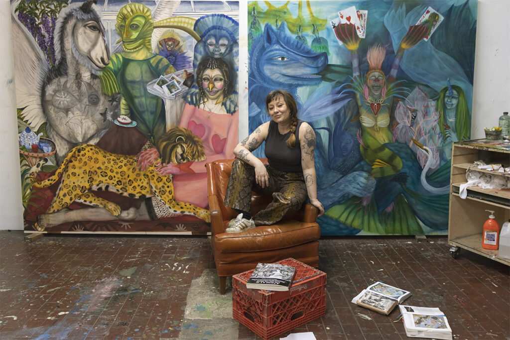 artist lydia maria pfeffer in her studio surrounded by paintings